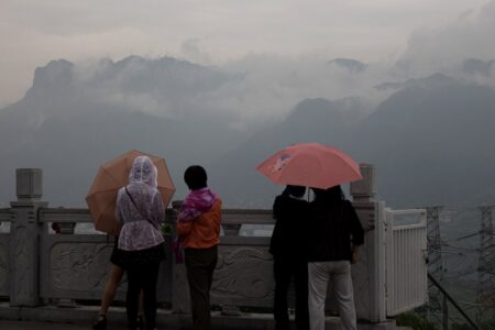 Personnes regardant les montagnes au loin par temps de pluie