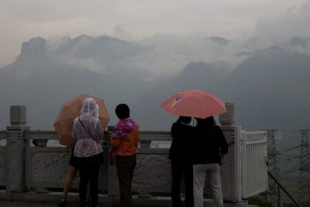 Personnes regardant les montagnes au loin par temps de pluie