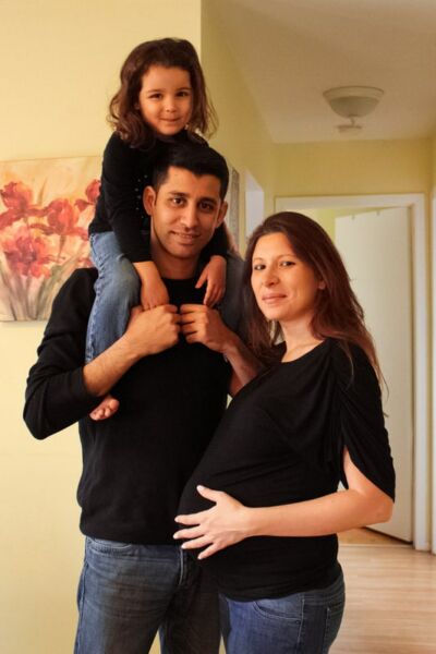 Couple dont la femme est enceinte et père portant sa fille susr ses épaules