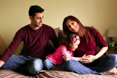 Couple avec fille qui touche le ventre de sa mère enceinte