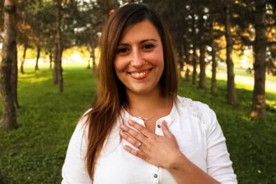 Portrait d'une jeune femme souriante au milieu d'arbres
