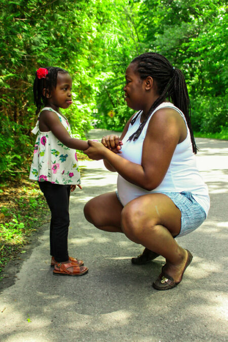 Mère et sa fille se faisant face. La mère tient la main de sa fille