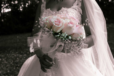 Plan serré sur une femme en robe de mariage tenant le bouquet
