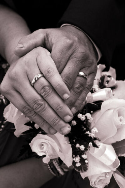 Gros plan sur les mains de mariés et leurs alliances