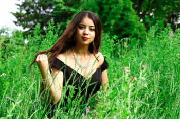 Jeune femme élégante posant entre dans des hautes herbes