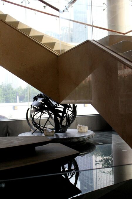 Photo d'une sphère construite en lamelle métallique sous un escalier